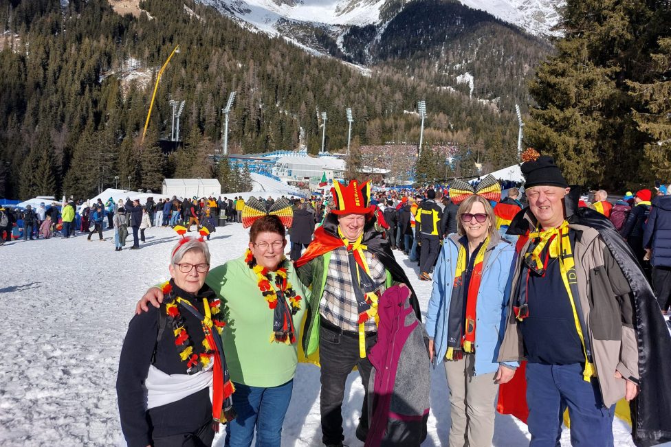 Familie und Freunde von Thierry Langer posieren in Antholz für ein Foto vor verschneiter Berglandschaft