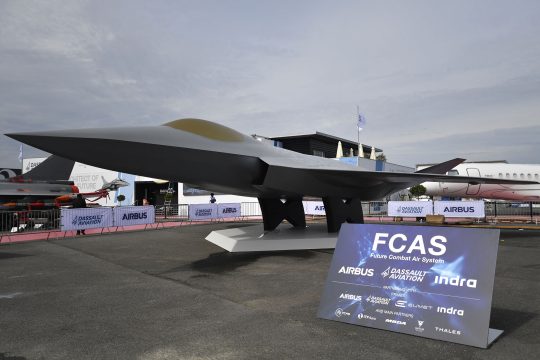 Das Modell eines Kampfjets, davor ein Schild mit der Aufschrift FCAS und den Logos der beteiligten Firmen Dassault Aviation, Airbus und Indra Sistemas