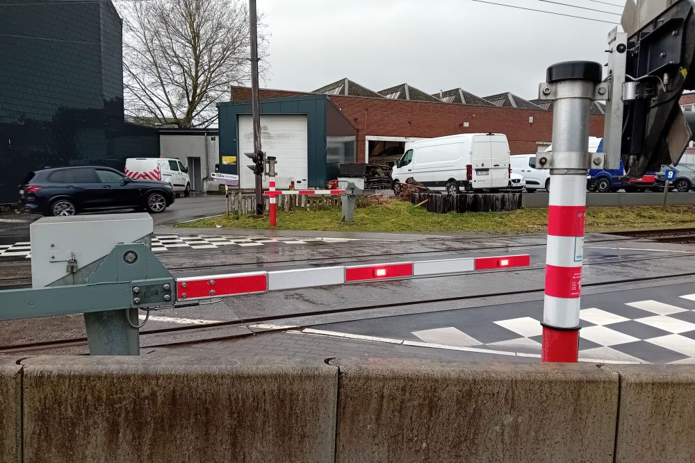 Ein ebenerdiger Bahnübergang mit geschlossener Schranke