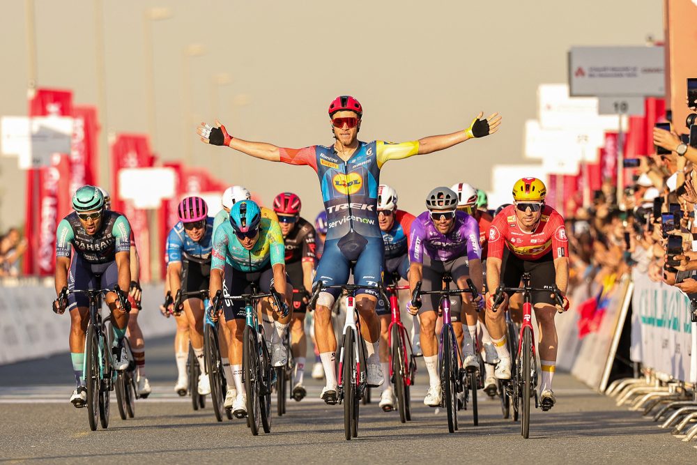 Jonathan Milan reckt bei der Zielankunft im Massensprint jubelnd die Arme in die Höhe