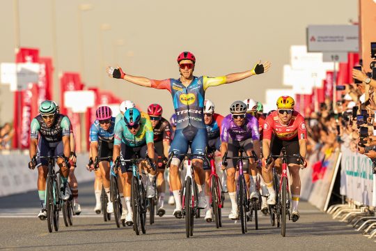 Jonathan Milan reckt bei der Zielankunft im Massensprint jubelnd die Arme in die Höhe