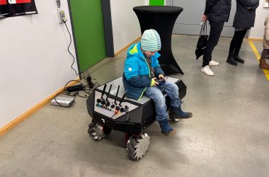 Junge auf einem Roboterfahrzeug bei der Lichternacht der Technik