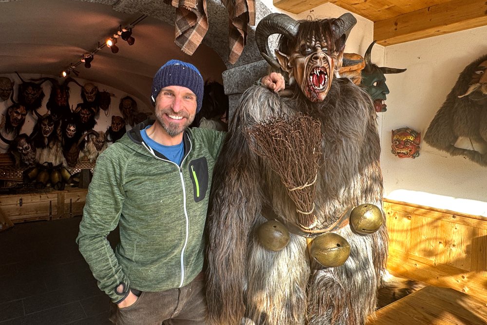 Maskenschnitzer Lukas Troi mit einer "Krampus"-Figur in seiner Werkstatt