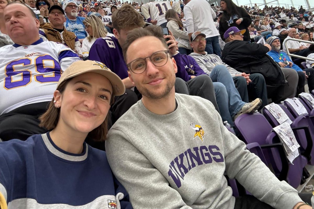 Marie Lilien und Markus Münch sitzen inmitten anderer Zuschauer in einem Sportstadion