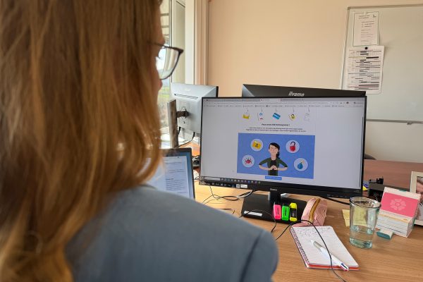 Mitarbeiterin Ekaterina Furtseva sitzt vorm PC, auf dem Bildschirm steht ein Hinweis, dass ein Phishing-Link angeklickt wurde