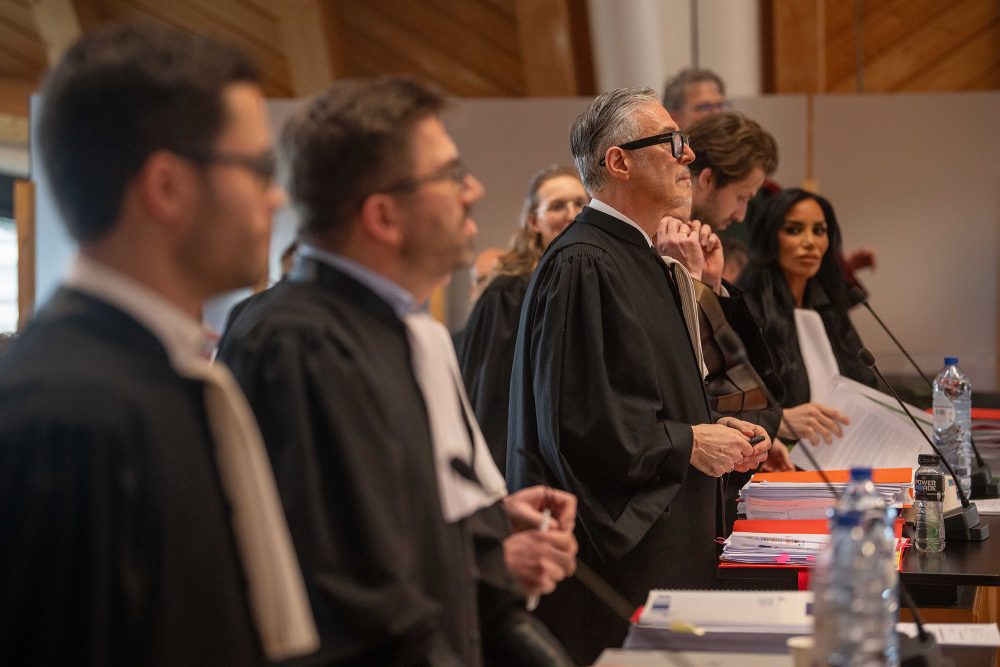 Rechtsanwälte in Robe stehen an ihren Plätzen im Gerichtssaal des Antwerpener Justizpalastes