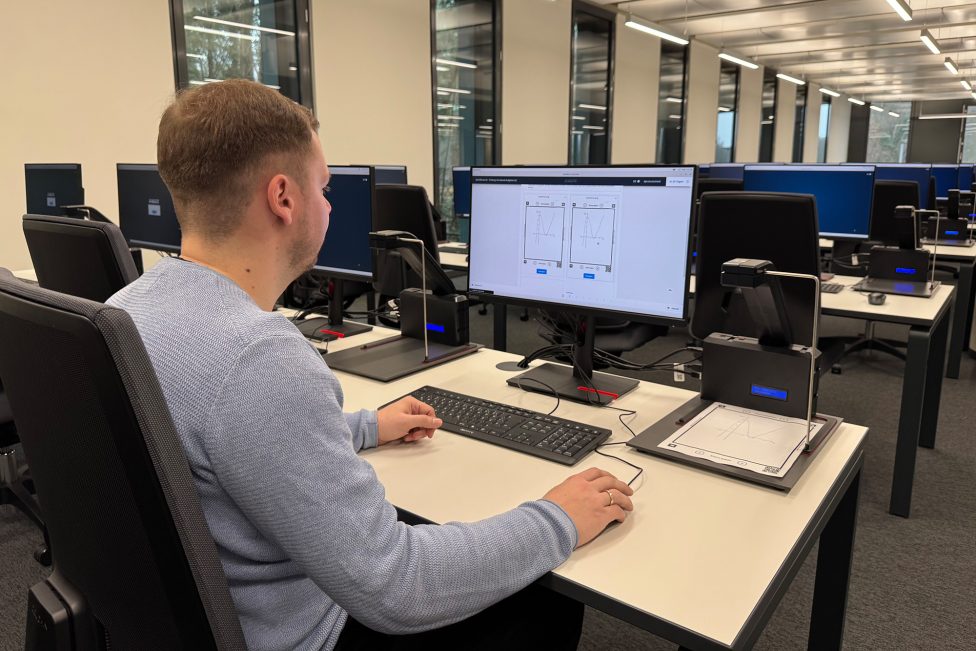 Ein Mann sitzt am PC und scannt etwas ein