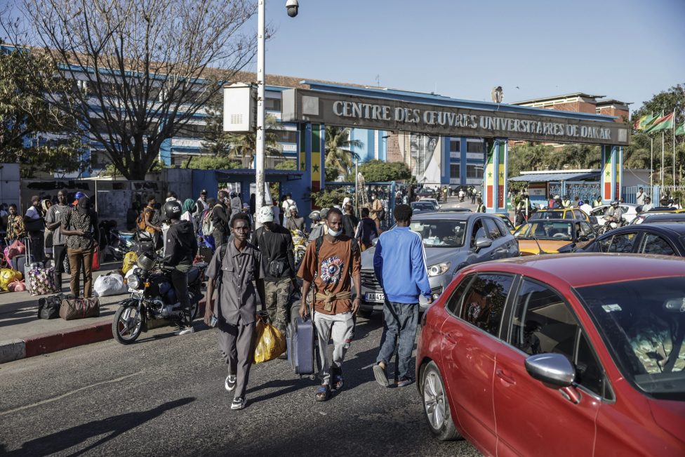 Motorräder, Autos und Studenten auf der Straße vor dem Gelände der Universität von Dakar