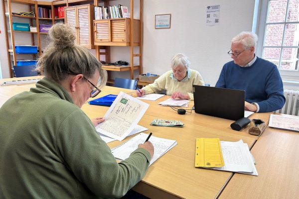 Die beiden Sütterlin-Übersetzerinnen Susanne Möller und Gesine Töpert am Tisch mit Hobby-Ahnenforscher Rainer Mertes