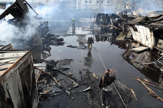 Feuerwehrleute bei Löscharbeiten in dem völlig zerstörten Gebäude