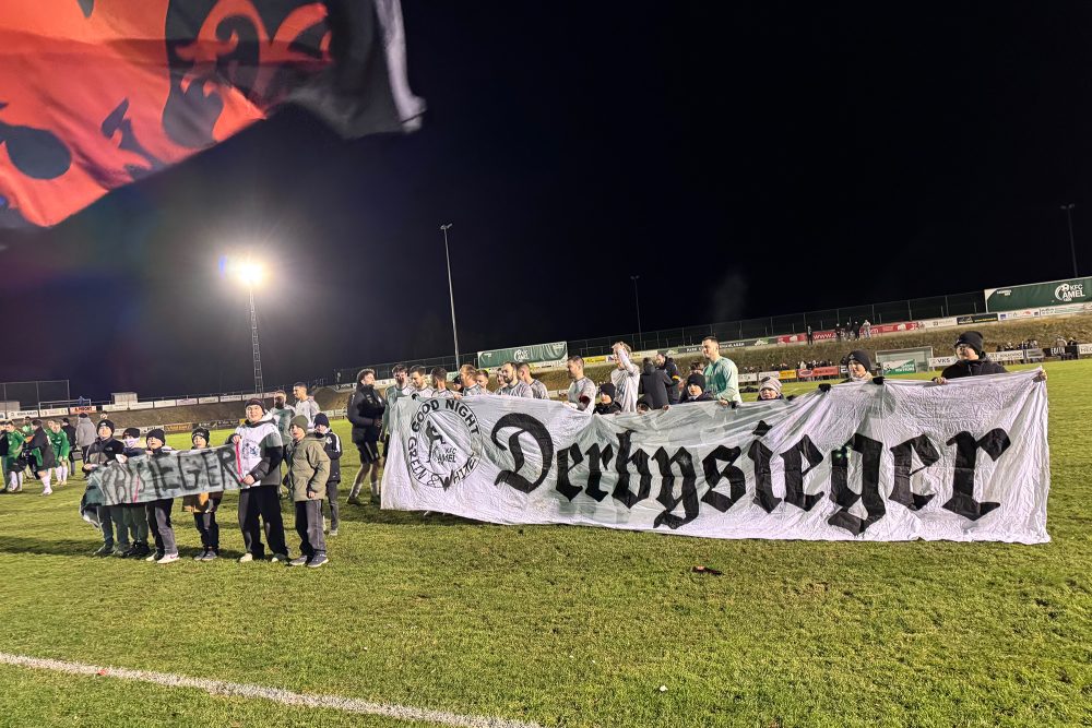 Die Spieler aus St. Vith halten ein Plakat mit der Aufschrift 'Derby-Sieger'