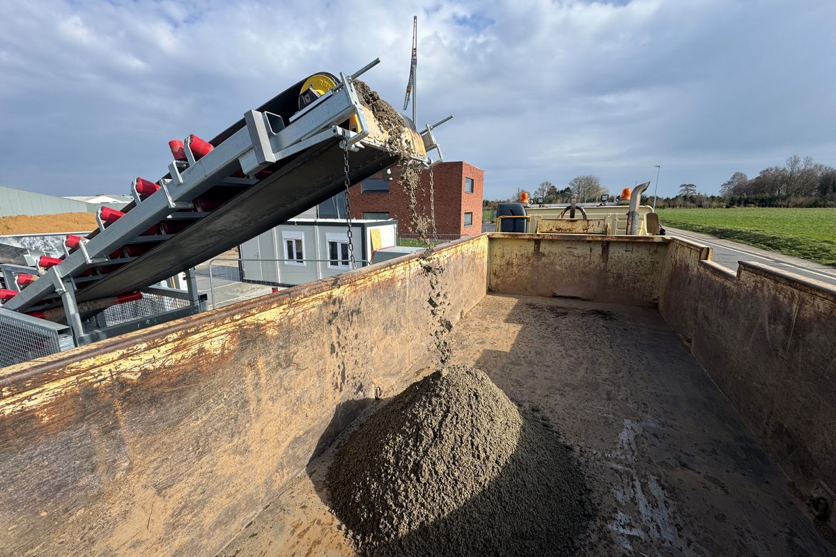 Hier wird der Beton über ein Fließband transportiert und fällt in den LKW