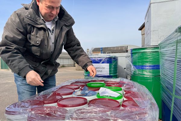 Betriebsleiter Alwin Lenges steht vor Eimern mit organischen Abfällen