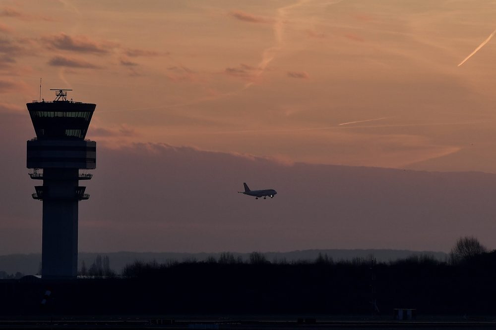 Tower am Brussels Airport mit Flugzeug vor dem Nachthimmel