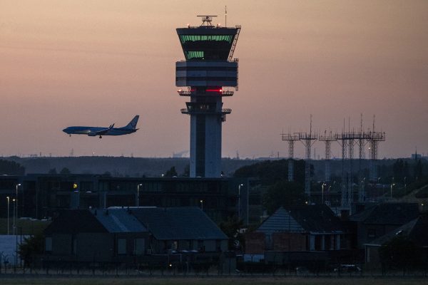 Tower am Brussels Airport mit Flugzeug vor dem Nachthimmel