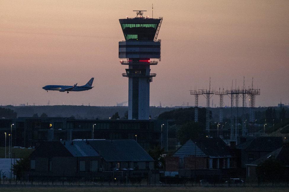Tower am Brussels Airport mit Flugzeug vor dem Nachthimmel
