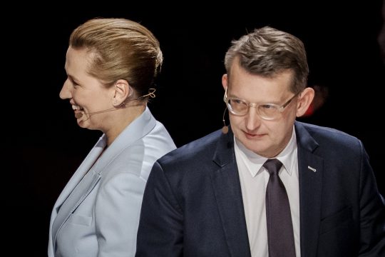 Mette Frederiksen und ihr Herausforderer Troels Lund Poulsen wenden einander den Rücken zu
