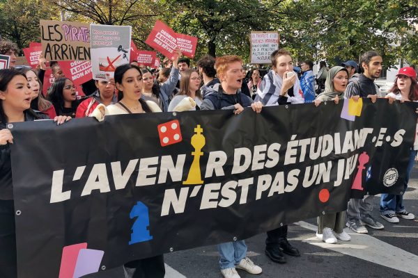 Studenten tragen ein großes Banner mit der Aufschrift "Die Zukunft der Studenten ist kein Kinderspiel" durch die Straßen