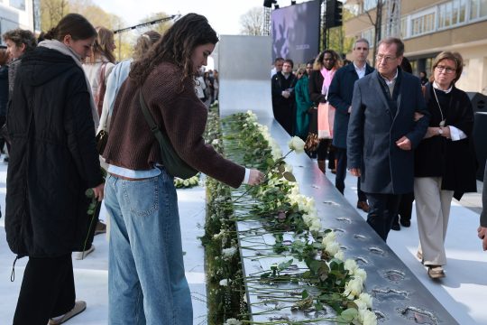 Junge Frau legt eine weiße Rose nieder bei der Gedenkfeier für die Opfer der Terroranschläge 2016 am 22. März 2026