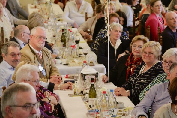 Publikum sitzt an Tischen bei der Benefizveranstaltung der VoG "Das Goldene Herz"