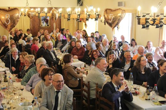 Publikum sitzt an Tischen bei der Benefizveranstaltung der VoG "Das Goldene Herz"