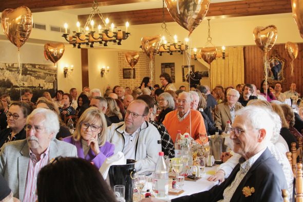 Publikum sitzt an Tischen bei der Benefizveranstaltung der VoG "Das Goldene Herz"