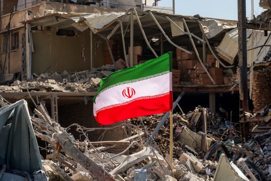 Iranische Flagge inmitten von Trümmern