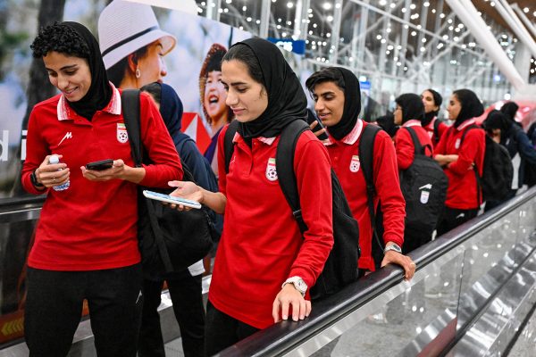 Fußballerinnen des iranischen Nationalteams auf einem Rollband am Flughafen