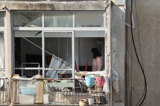 Eine Frau steht in einem Gebäude in Tel Aviv, das durch einen iranischen Raketenangriff beschädigt wurde