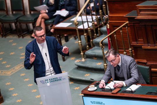 Raoul Hedebouw von der PTB steht am Rednerpult, Bart de Wever nimmt Notizen