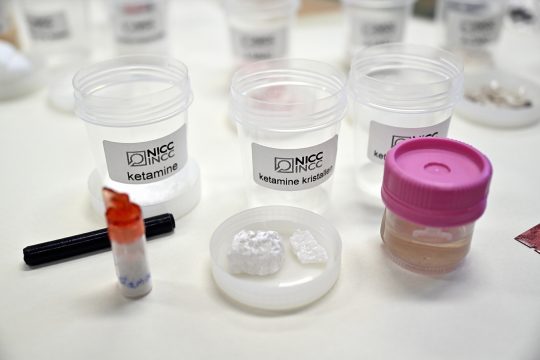 Becher mit verschiedenen Drogen, darunter Ketamin, auf einem Tisch