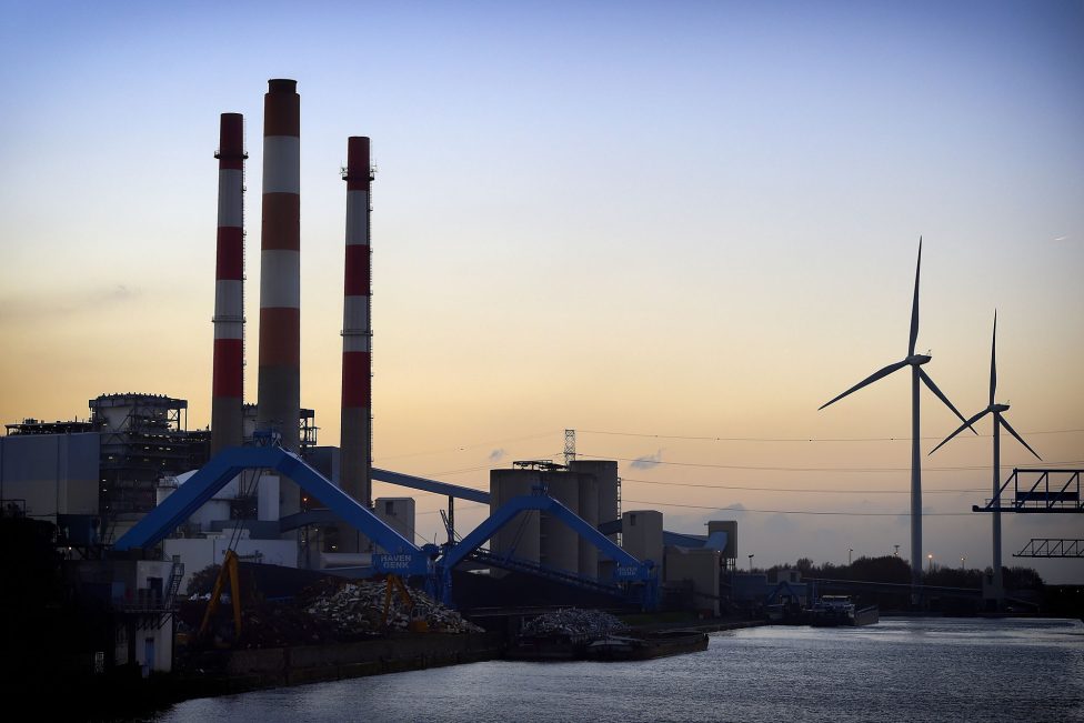 Schornsteine und Türme des ehemaligen Kraftwerks, dahinter Windräder