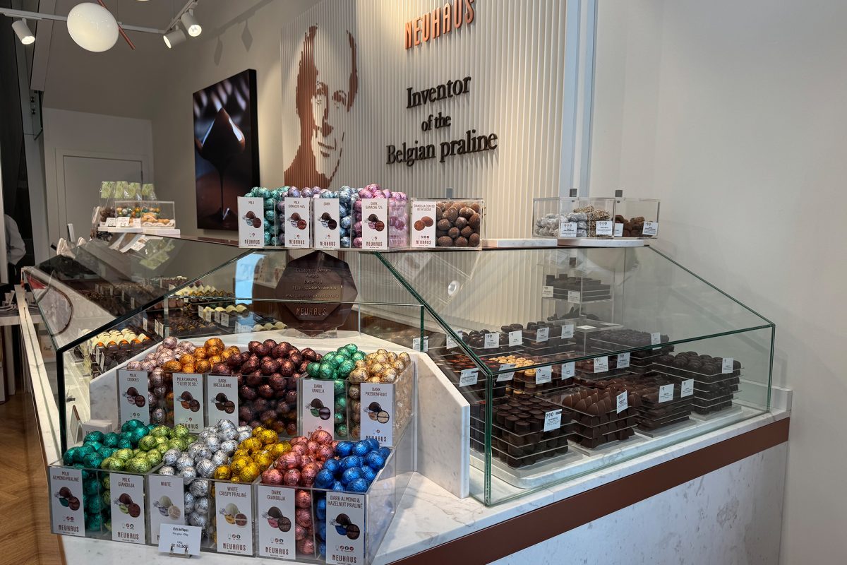 Verkaufstresen der Chocolaterie Neuhaus mit vielen verschiedenen Pralinen und weiteren Schokoladenspezialitäten