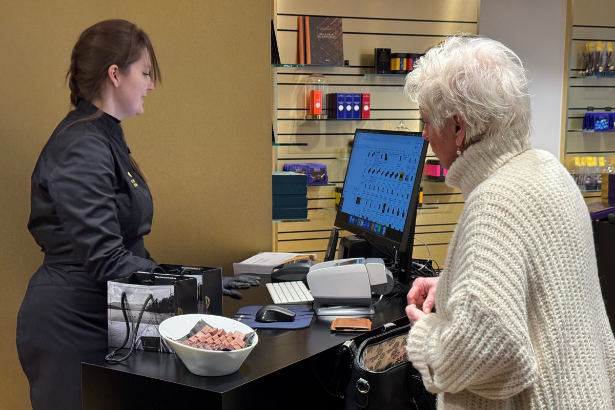 Eine Kundin steht am Verkaufstresen, eine Verkäuferin bedient sie