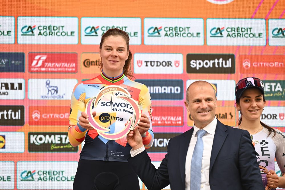 Lotte Kopecky mit Trophäe auf dem Podium bei Mailand-Sanremo