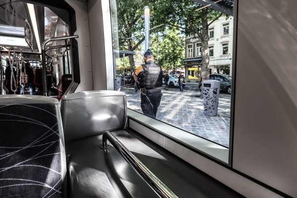 Innenraum der Tram, durch das Fenster ist ein Polizist in Uniform zu sehen