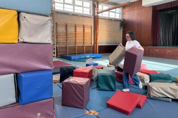 Kindergärtnerin Annette Johnen räumt die Kissen vom Turnen weg