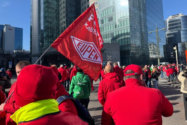 Gewerkschaftsmitglieder versammeln sich auf zentralem Platz in Brüssel, auch eine Gewerkschaftsflagge von Mitarbeitern des Kabelwerk Eupen ist zu sehen