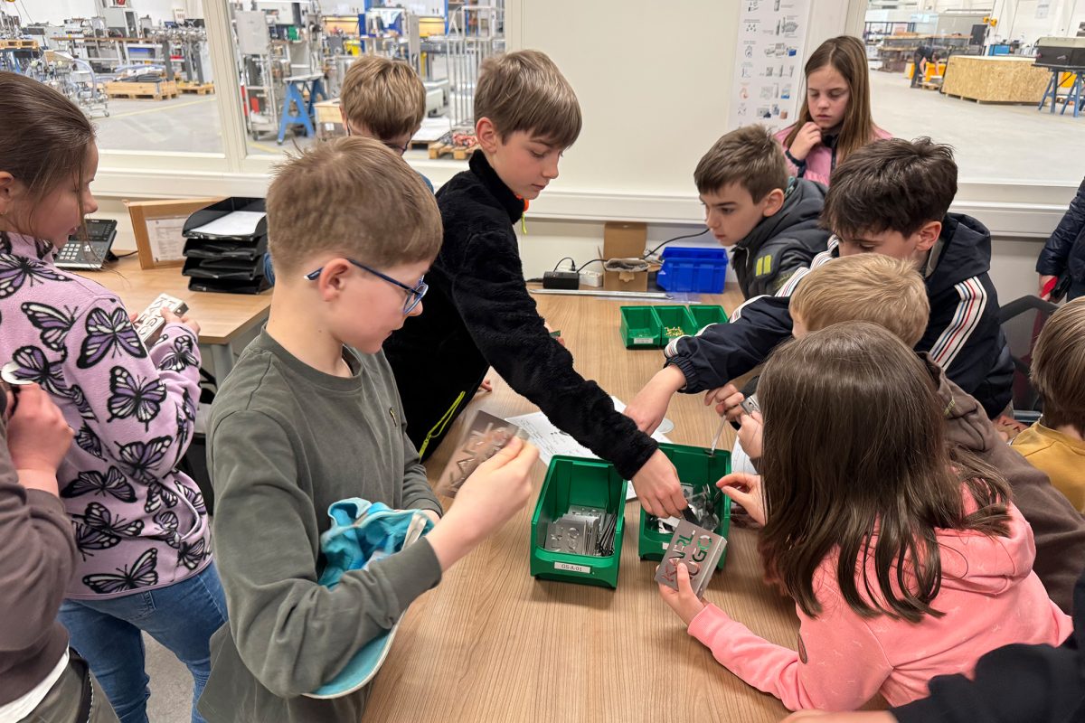 Die Kinder sitzen an einem Tisch und bauen selbst etwas zusammen