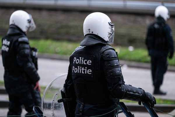 Drei Polizisten in Schutzmontur mit Helm und Schutzschild