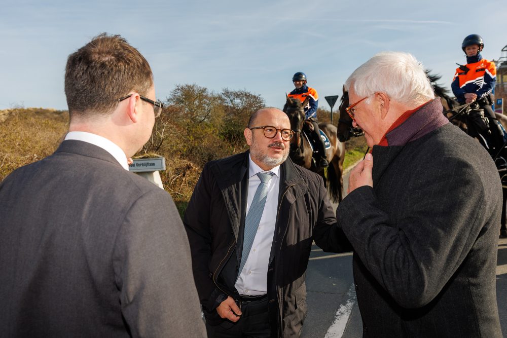Der britische Minister, der belgische Innenminister und der Gouverneur der Provinz Westflandern im Gespräch am Strand von Adinkerke