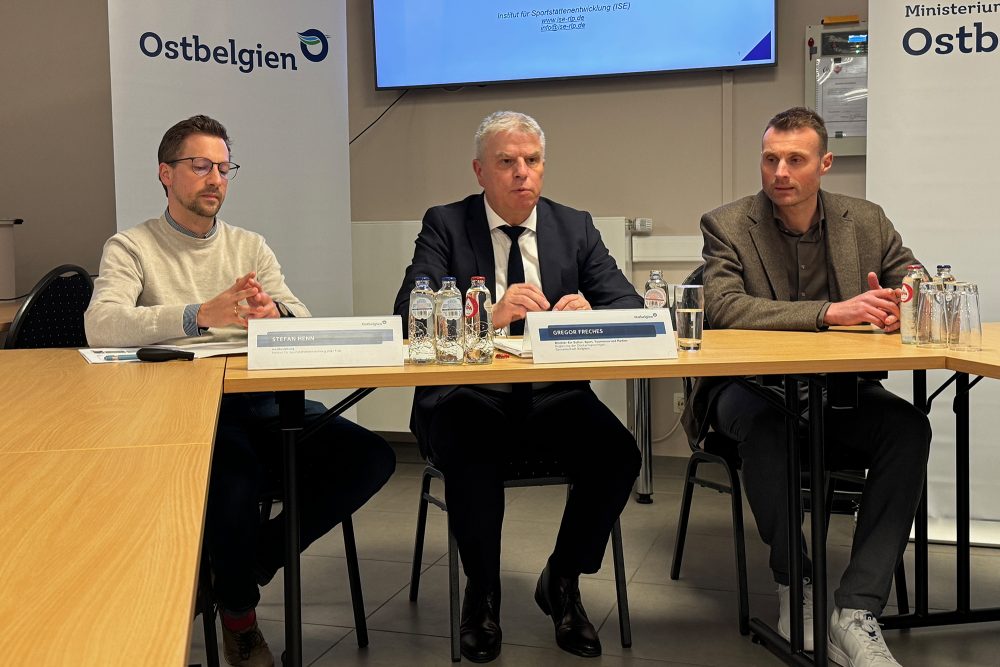 Projektleiter Stefan Henn, DG-Sportminister Gregor Freches und Ministeriumsmitarbeiter Olivier Esser sitzen bei einer Pressekonferenz an einem Tisch