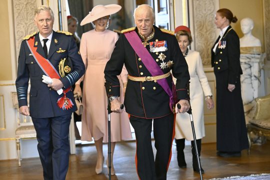 König Philippe und König Harald von Norwegen gehen durch einen Saal, hinter ihnen folgen Königin Mathilde und Königin Sonja von Norwegen