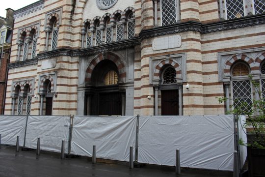 Die Synagoge in Lüttich in der Rue Leon Fredericq, vor dem Gebäude ist eine Absperrung mit einem Sichtschutz aufgestellt worden