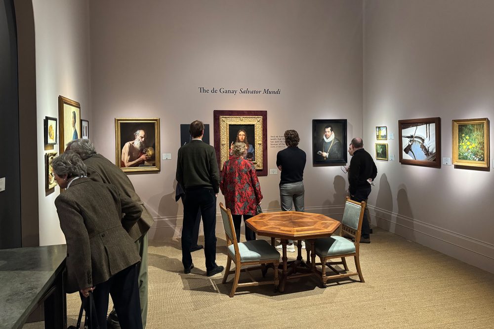 Besucher schauen sich Gemälde in einem Ausstellungsraum an, darunter "Salvator Mundi" von Leonardo Da Vinci