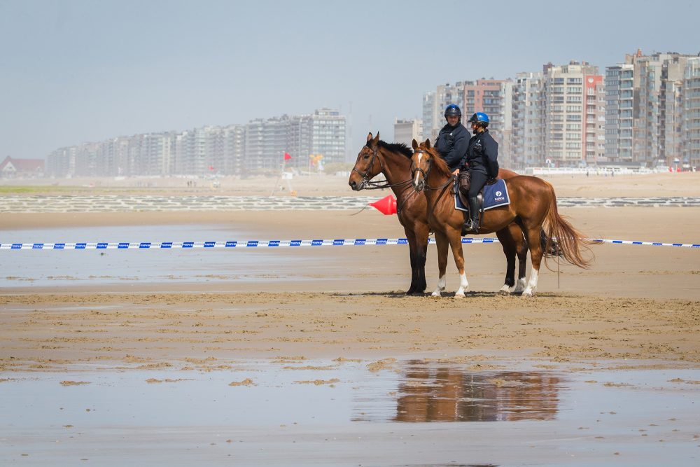 Zwei Polizisten zu Pferd am Strand von Westende