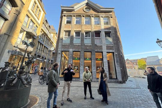 Gebäude mit historischer Fassade in Aachen, davor mehrere Personen