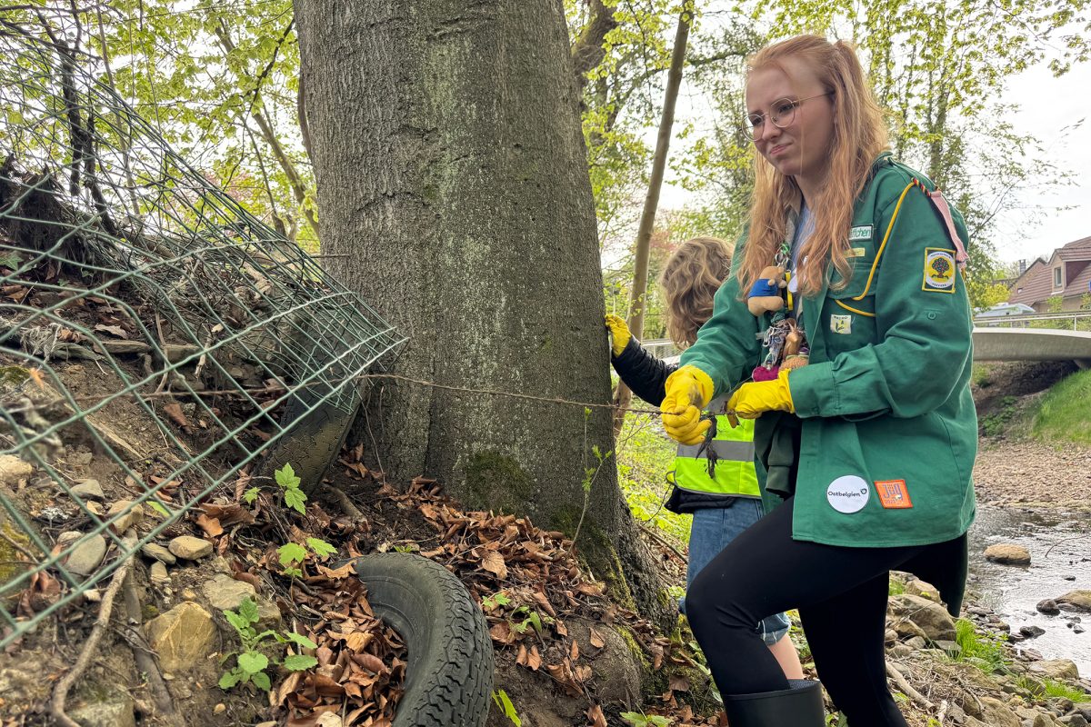 Mädchen beim Müllsammeln am Flussufer