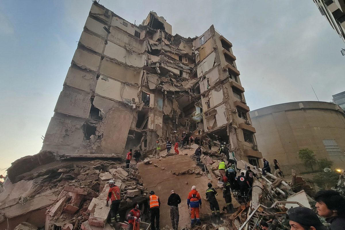 Rettungskräfte und Anwohner vor einem durch einen israelischen Luftangriff zerstörten mehrstöckigem Wohnhaus