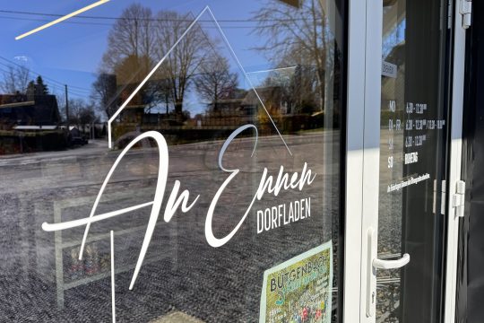 Logo auf der Scheibe des Dorfladens "An Ennen" in Elsenborn
